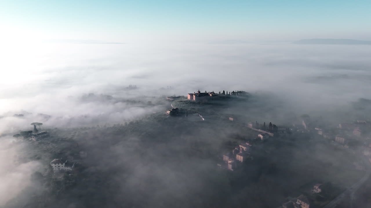 Veduta aerea della nebbiosa Siena e dei suoi dintorni toscani all'alba, serena e tranquilla.