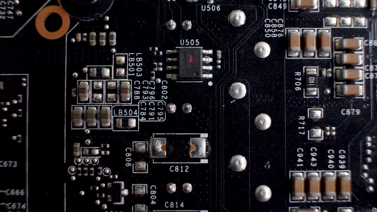 A close-up of the rear side of a graphics card reveals the PCB, a slender platform accommodating various chips and electronic elements