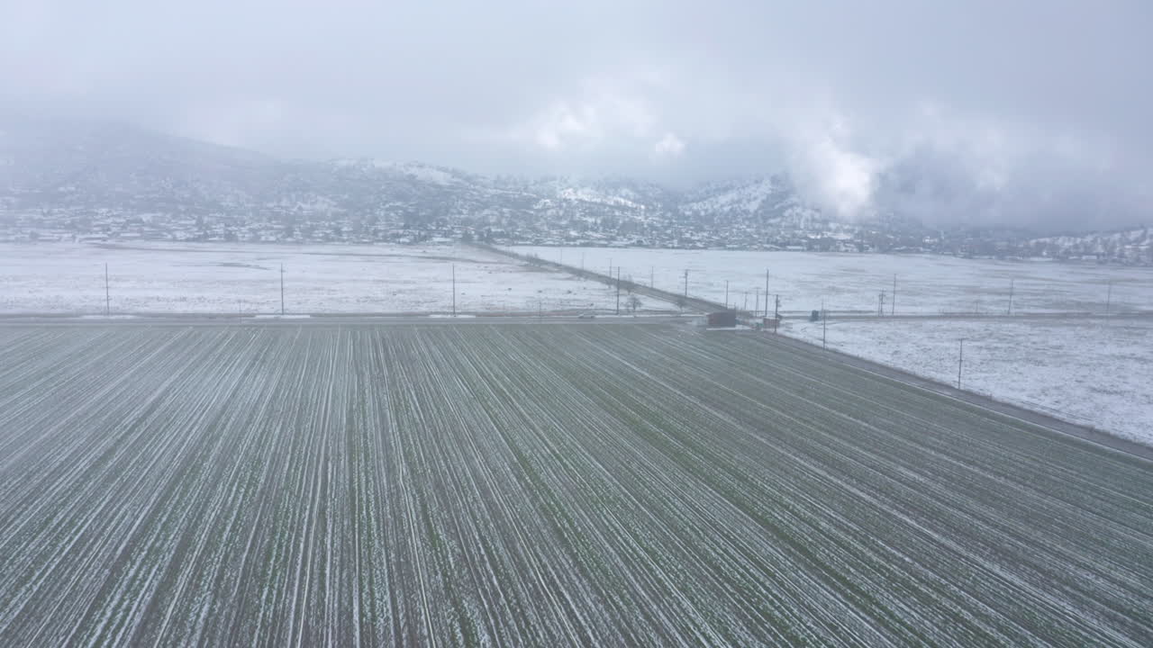 캘리포니아 테하차피에 있는 겨울 눈 덮인 농장 위로 눈보라를 뚫고 날아갑니다.