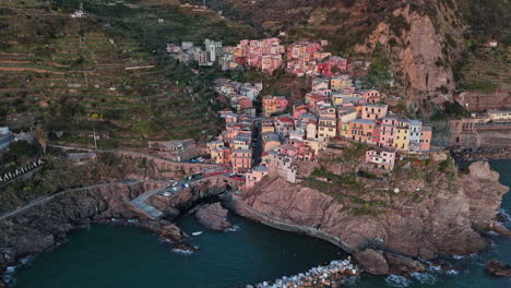 colorful houses in manarola, cinque terre, at sunset over the ocean, aerial view