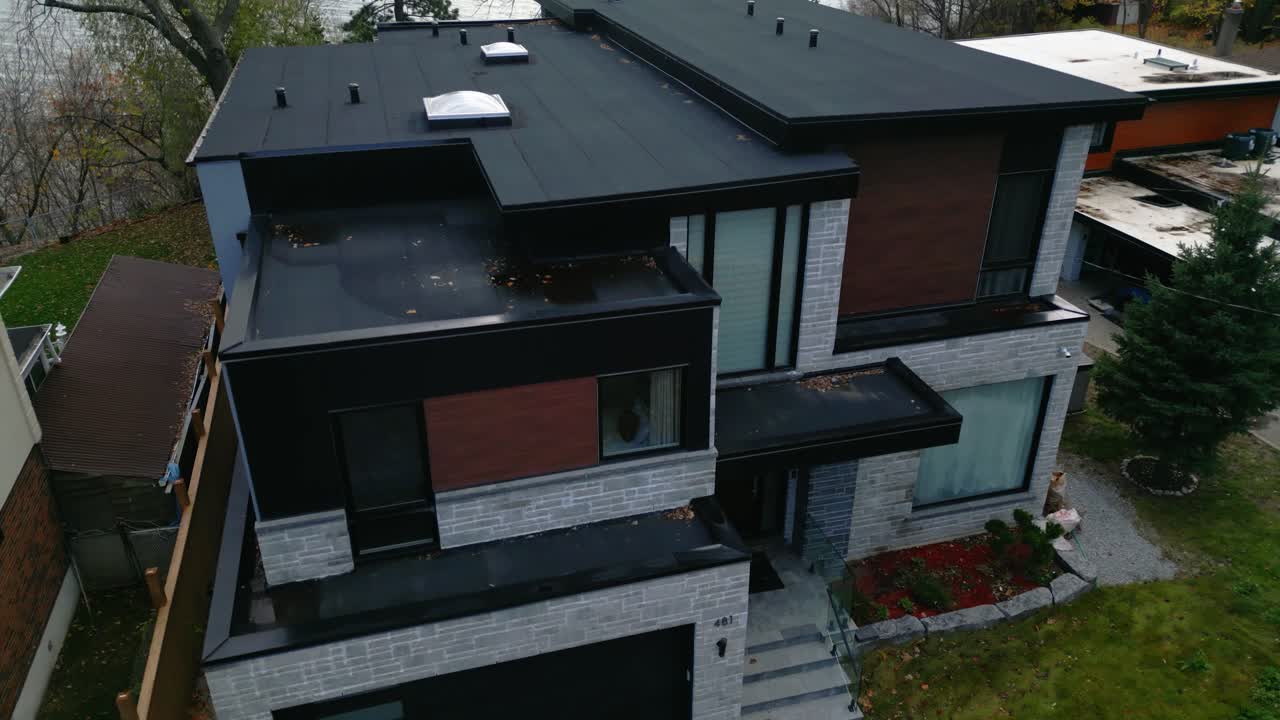 A frontal view of a luxurious suburban house with large windows and minimalistic modern design aesthetics, black and grey accents
