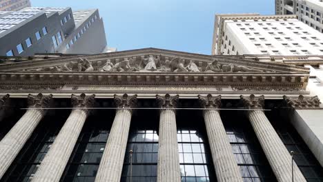 panning from top to bottom at the new york stock exchange nyse with us flags on wall street in manhattan