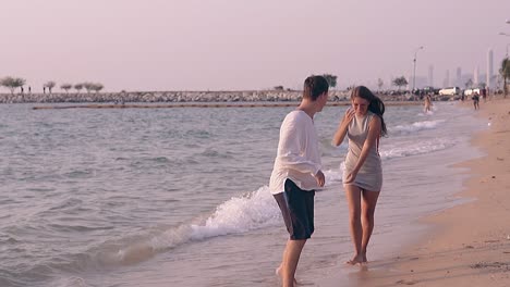 barefoot couple walks along pictorial sea coast slow motion