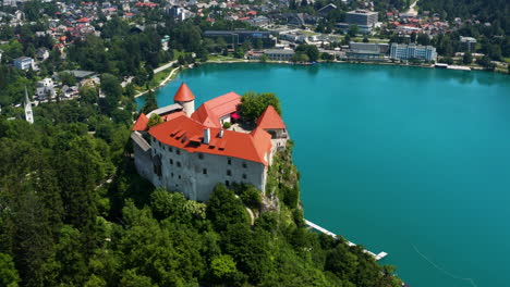 Bleder-Burgmuseum-Auf-Einer-Steilen-Klippe-Mit-Blick-Auf-Das-Türkisblaue-Wasser-Des-Bleder-Sees-In-Den-Julischen-Alpen-Der-Region-Oberkrain-In-Slowenien