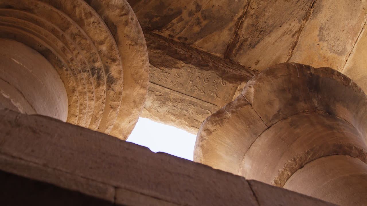 Close-up of ancient stone columns with intricate carvings at the Dendera Temple in Egypt