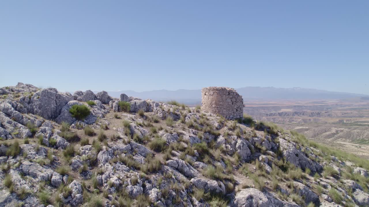 Ruins of a medieval watchtower on a rocky mountaintop. Aerial view of the watchtower and horizon. Spain