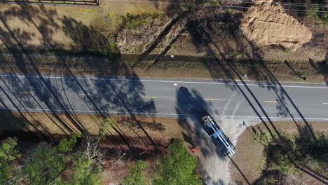 A-bird's-eye-view-shot-looking-down-at-a-back-road-near-a-farm