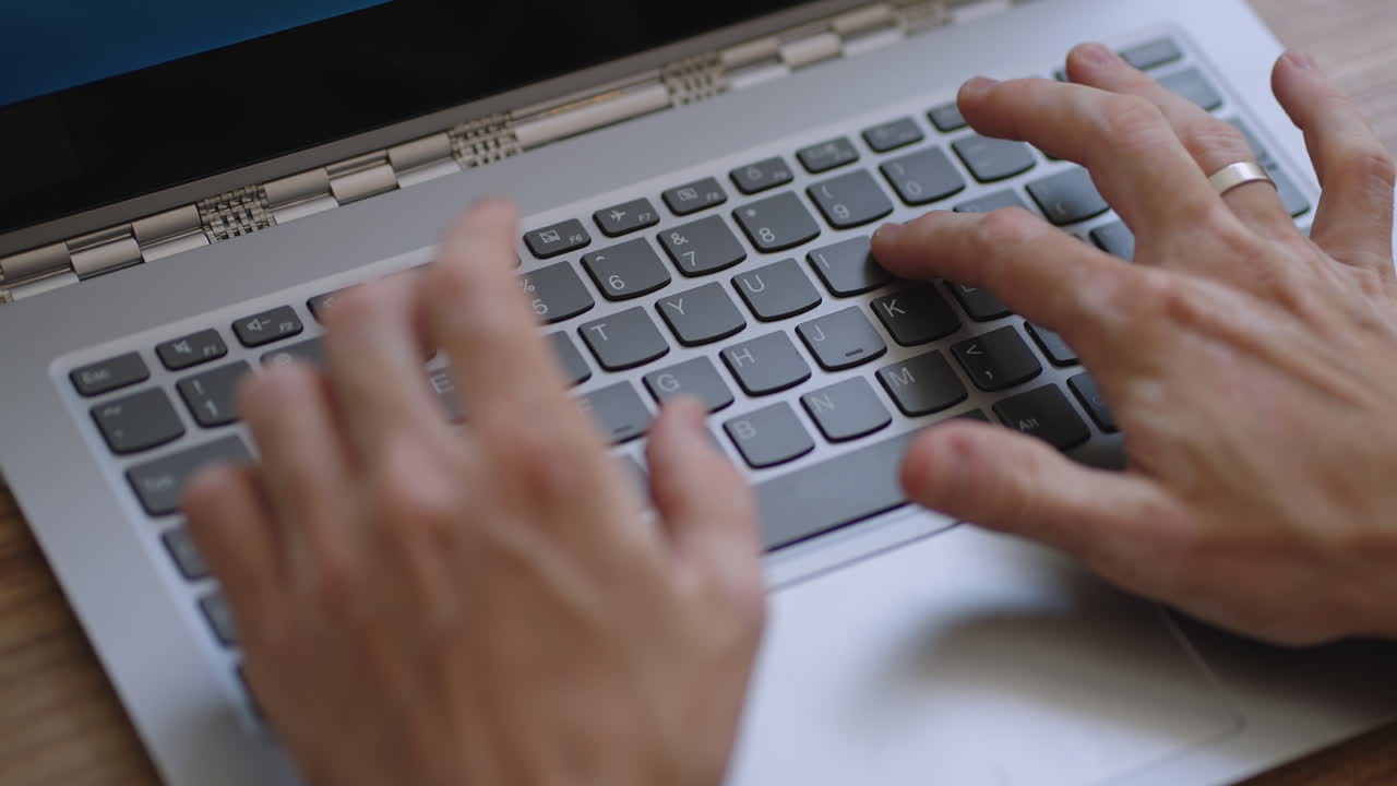 Male hands of business man professional user worker using typing on laptop notebook keyboard sit at home office desk working online with pc software apps technology concept close up side view