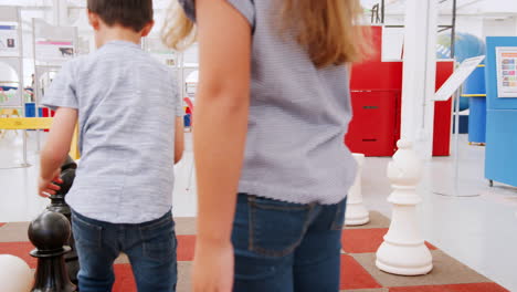 young kids playing giant chess at a science centre, close up
