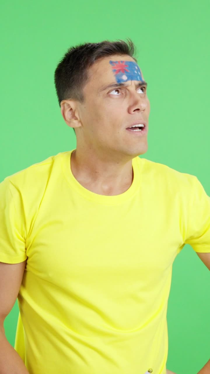 Nervous man cheering for Australia during a match looking away