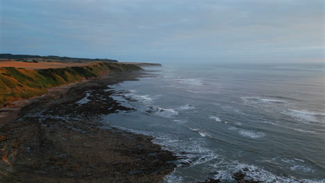 high establishing aerial drone shot at golden hour of cleveland way on misty morning