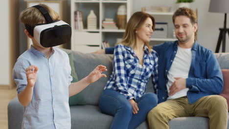 small cute boy in the vr glasses having a vr headset in the living room