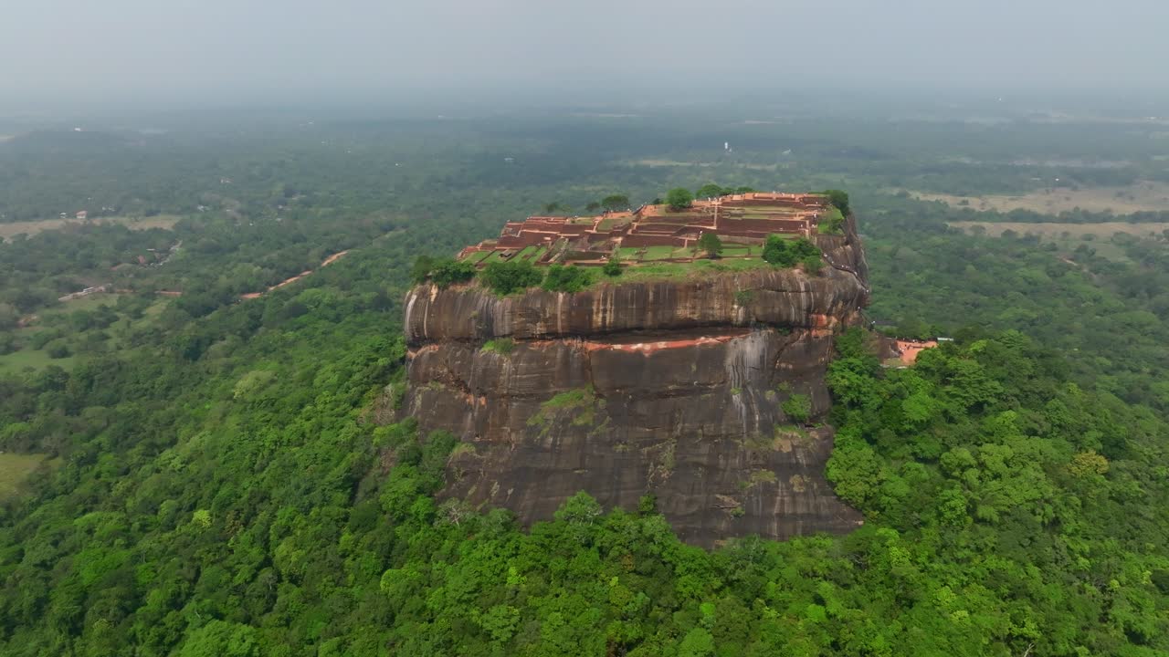 Dronebilde av Sri Lanka rett over Sigiriya Rock Fortress, som viser hele oppsettet av toppen, gårdsplassene og reservoarene i levende grønt