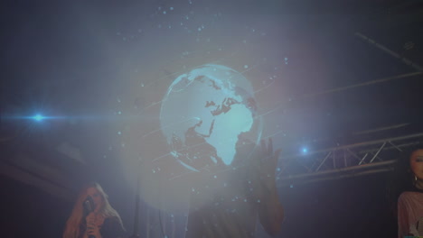 trio performing on stage with music tech, projecting holographic earth globe and lock icons