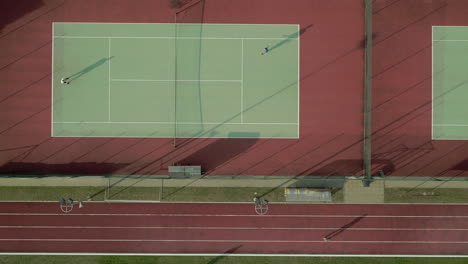 drone shot above tennis courts with people playing tennis