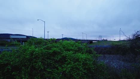 Cielo-Sombrío-Sobre-Una-Carretera-Con-Semirremolques,-Destacando-La-Industria-Del-Transporte-Y-La-Logística