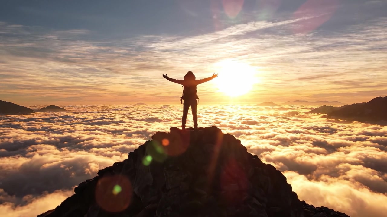 Uma Vista Deslumbrante Acima das Nuvens: Uma Silhueta de um Caminhante de Pé no Pico de uma Montanha ao Pôr do Sol, Rodeado por um Mar de Nuvens e Cores Vibrantes no Céu