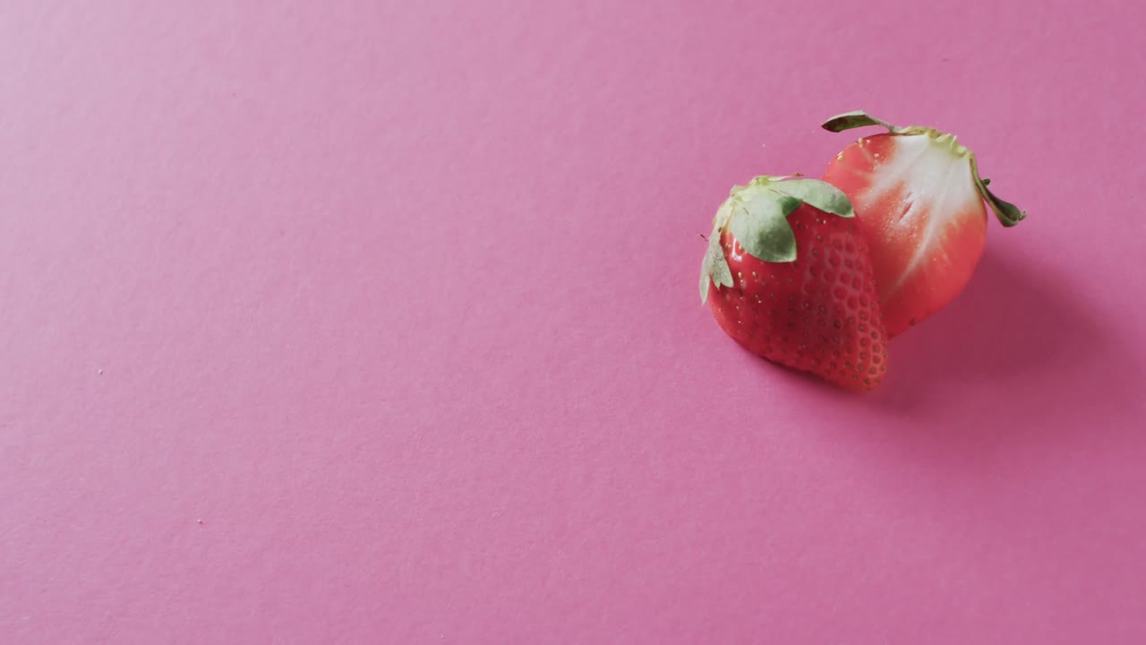video de fresa cortada por la mitad con espacio de copia sobre fondo rosa