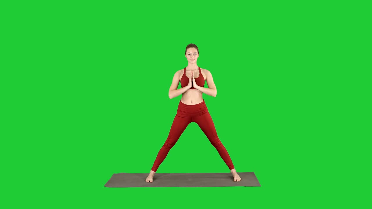 Jovem mulher praticando ioga, termina de fazer o exercício Utthita parsvakonasana em uma Tela Verde, Chroma Key