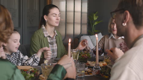 family holding hands and praying before meal at home