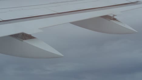 close-up of airplane wing flying in the air with clouds