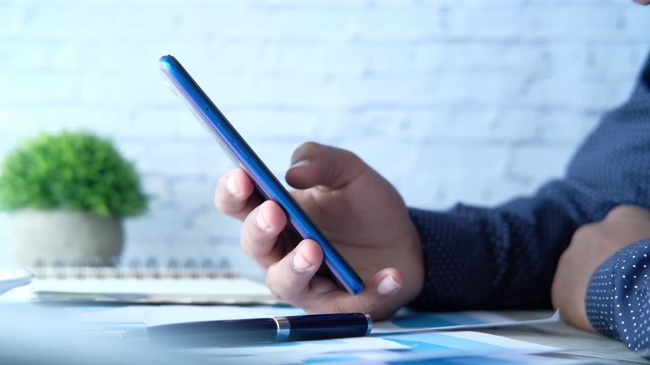 persona que utiliza un teléfono inteligente en un escritorio