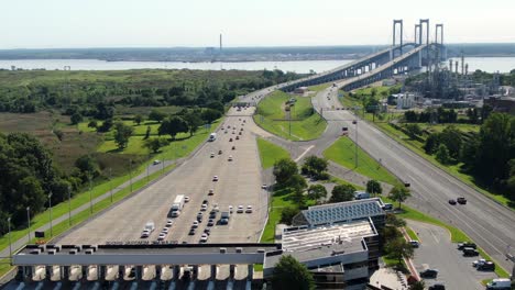 Aerial-pullback-reveals-turnpike-toll-booth-plaza-at-Delaware-Memorial-Bridge-between-New-Jersey-and-Delaware,-USA