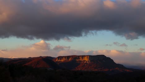 Timelapse-of-a-mountain-range-with-clouds-passing-by-while-getting-dark