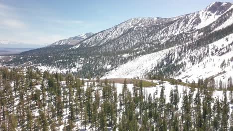 slow aerial flight over a snowy ridge to reveal a vast mountainous valley