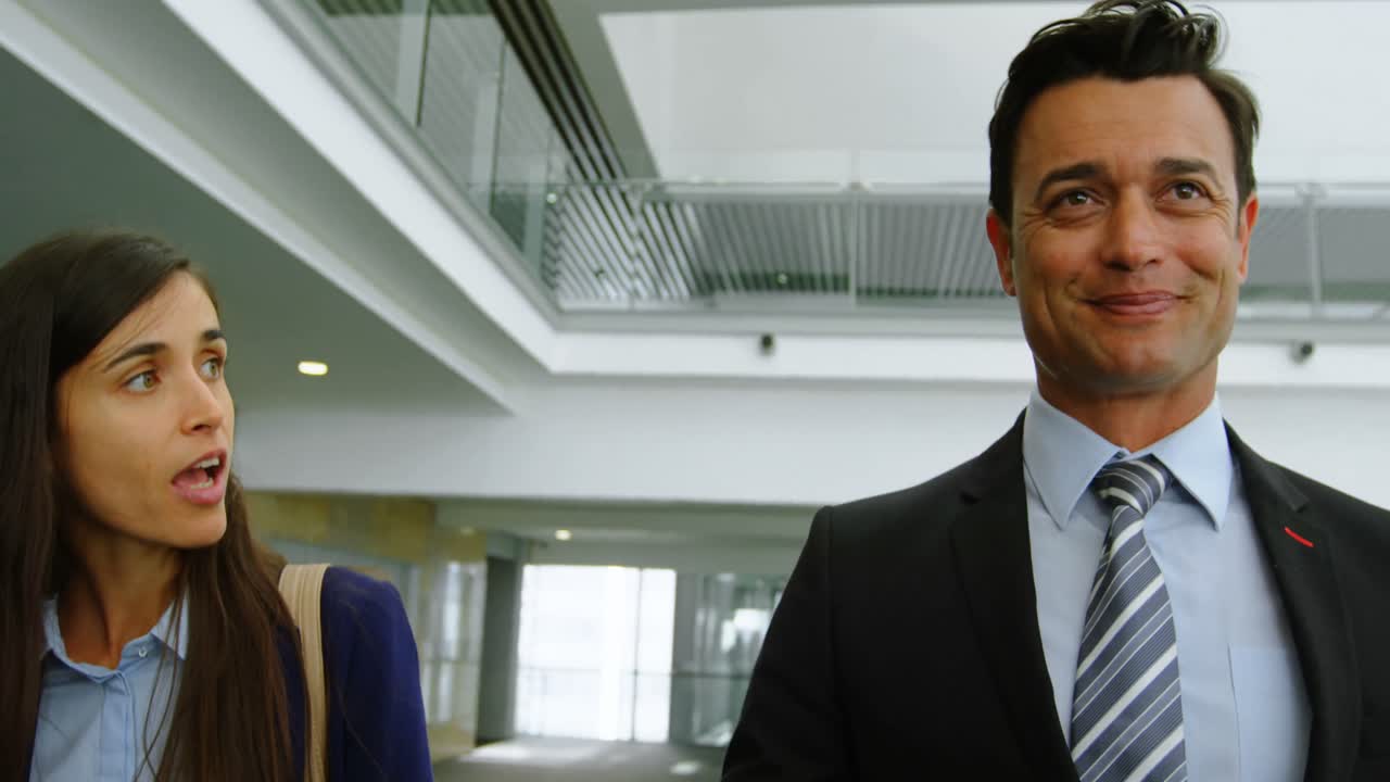 hombre de negocios y mujer de negocios hablando en la oficina 4k