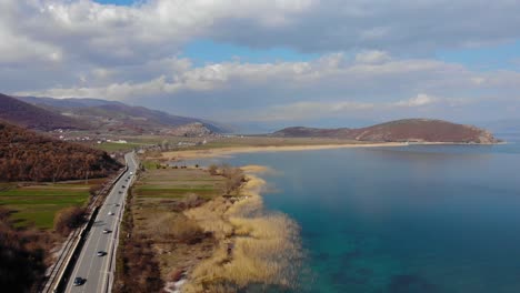 coches conduciendo por una carretera panorámica junto a la orilla del lago en un hermoso día de primavera