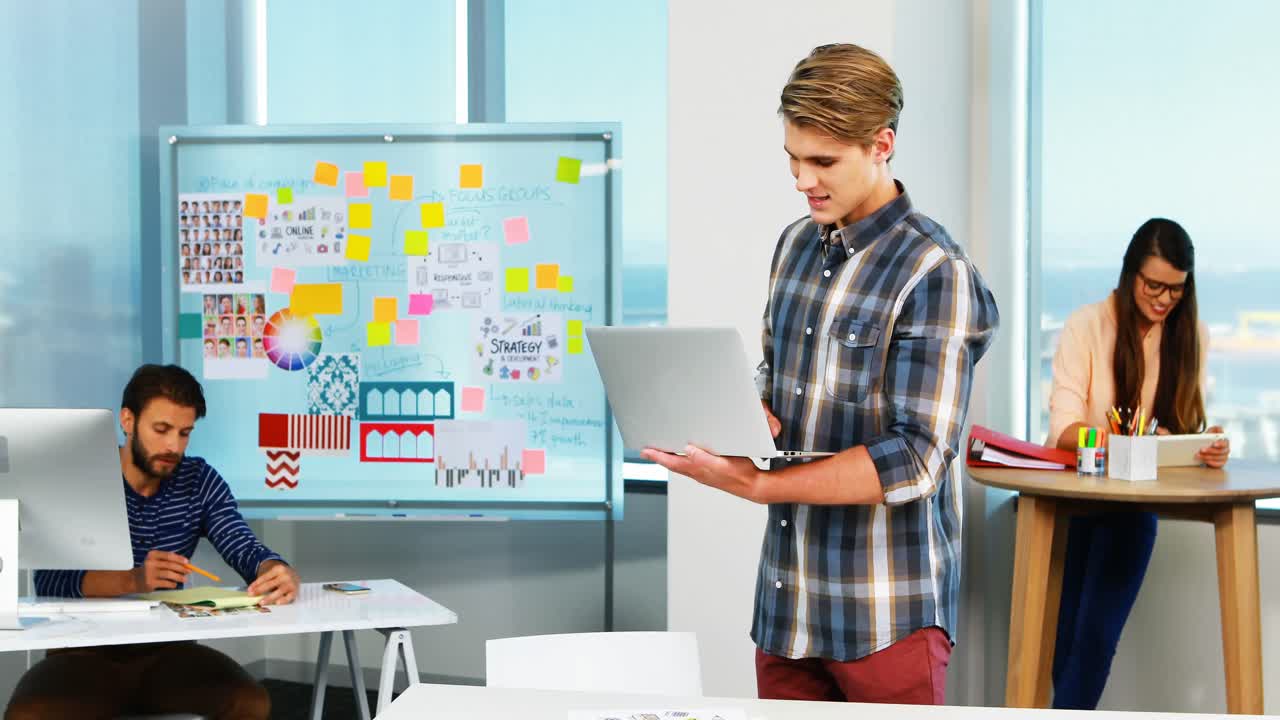 diseñador gráfico masculino usando una computadora portátil en la oficina