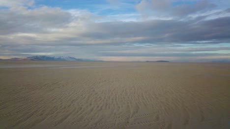 a drone flys low to the sand near antelope island in the great salt lake of utah