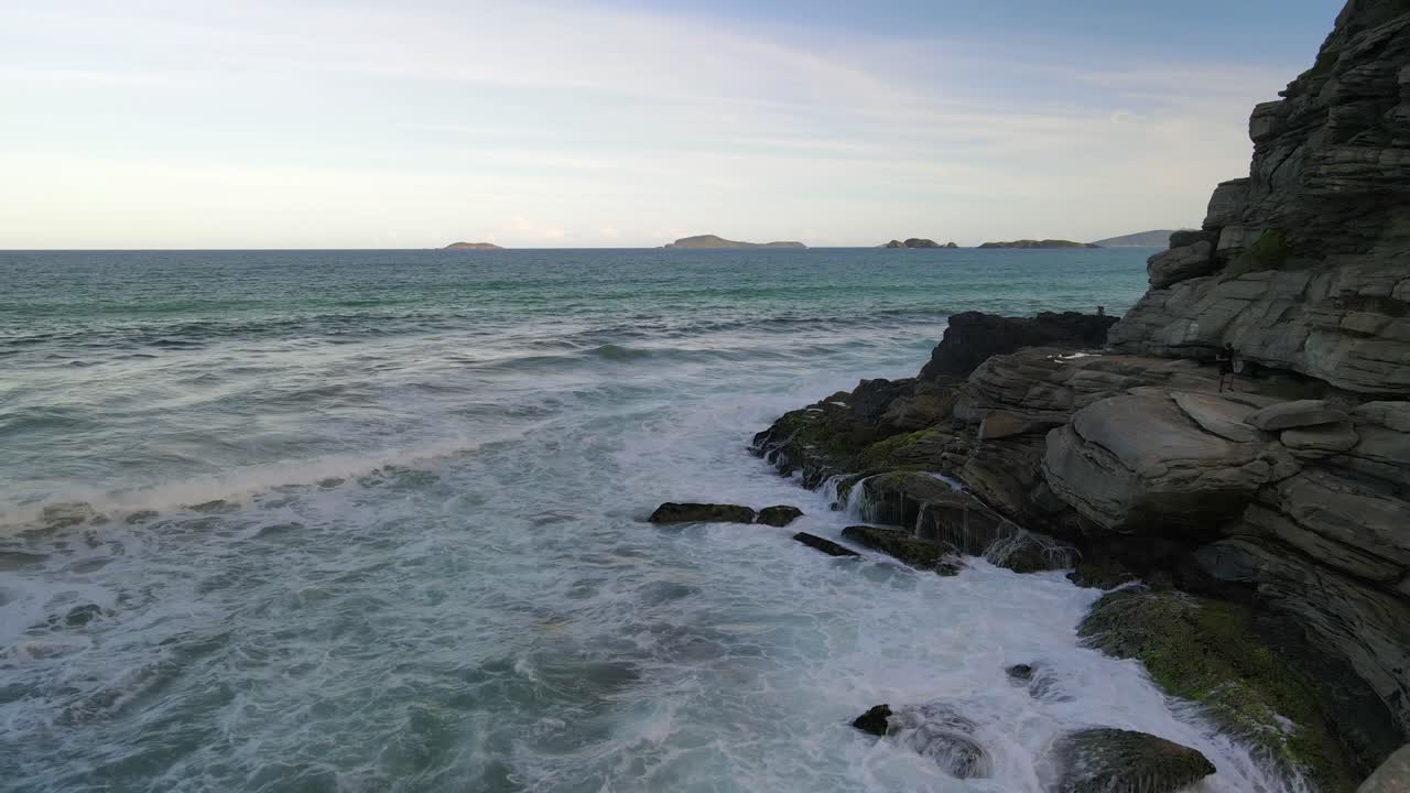 Onde oceaniche che si infrangono su una scogliera rocciosa a Geriba Beach, Buzios, Brasile.