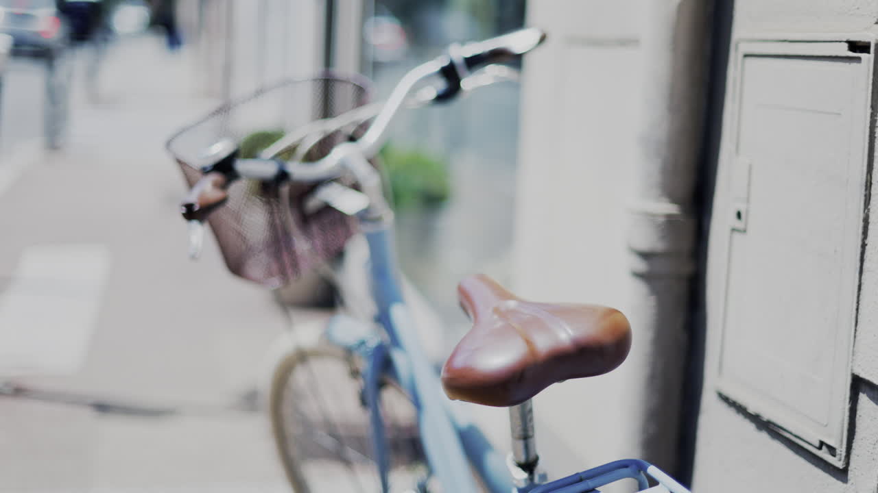 Close up of a blue bicycle with a brown seat on the street