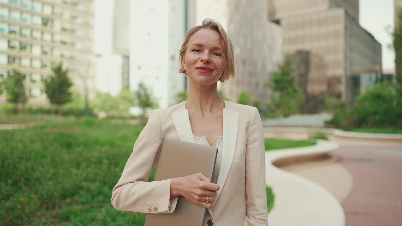 Businesswoman with laptop in city setting