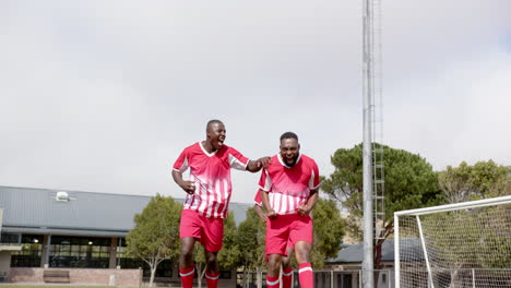 celebrating victory, three african american soccer players in red jerseys on field