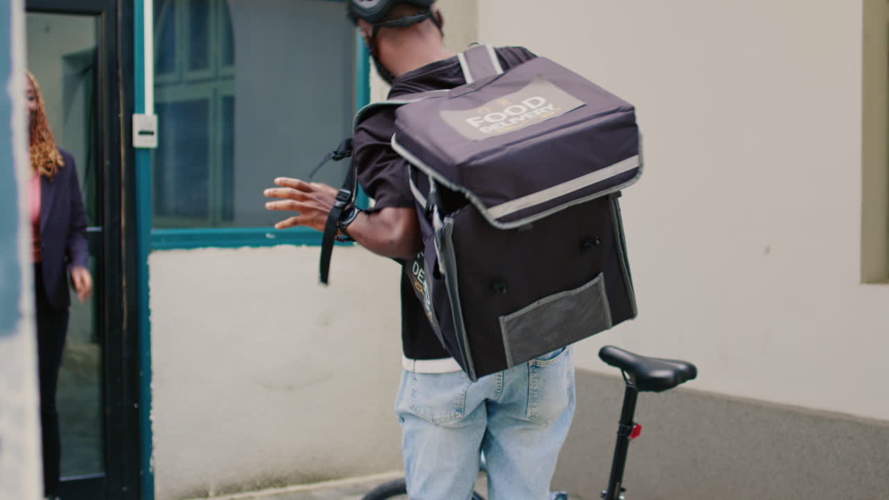 A food delivery courier riding a bicycle in an urban environment