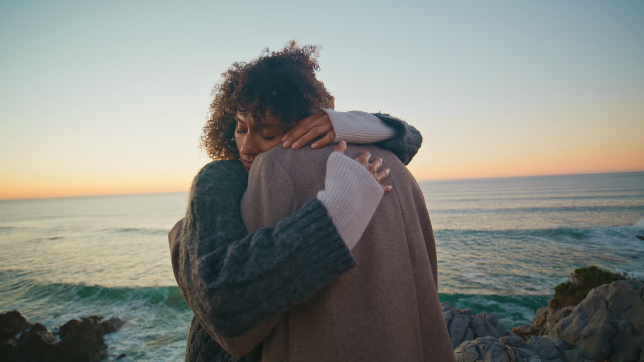 Loving couple hugging dusk coast hill closeup. Man curly woman bonding at ocean