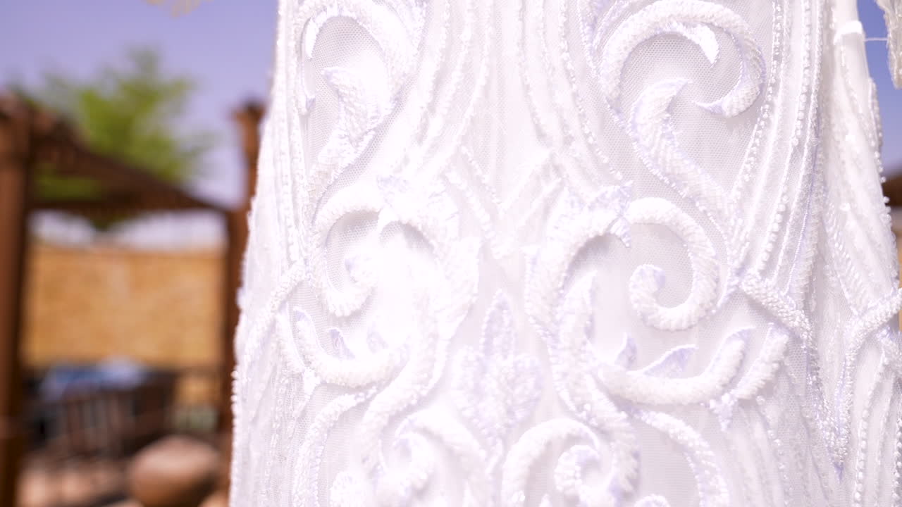 The bride's dress hanging among the plants in the garden