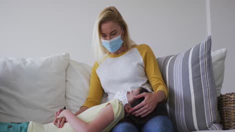 mother and daughter wearing face masks playing with each other at home