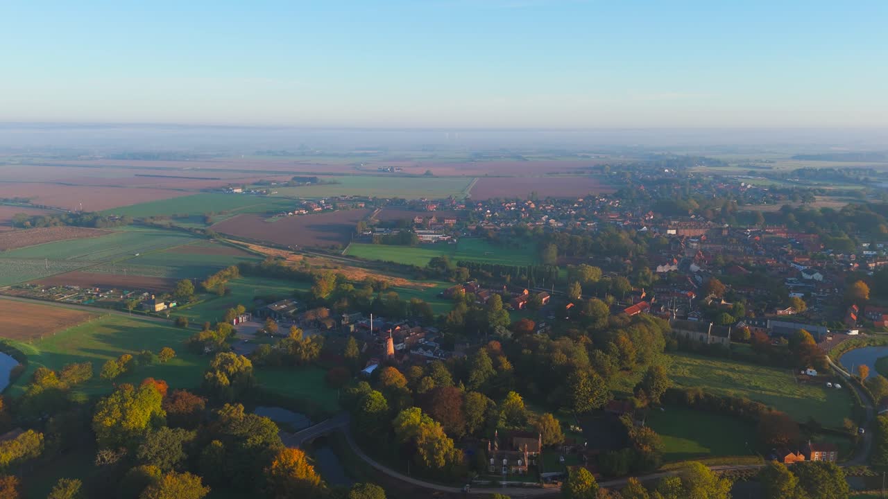 Misty autumn morning with farmlands and countryside views, wide vistas across open fields with crops set for overwintering. cold days in a rural village setting