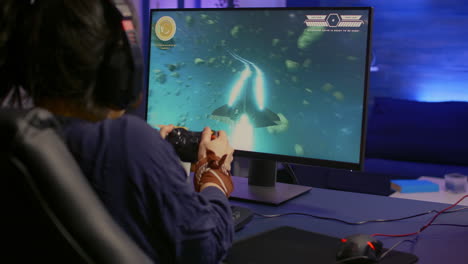 vista de atrás de un jugador profesional ganando un juego de disparos espaciales