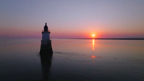 old derelict lighthouse in very calm waters with sunset reflecting. stationary shot. plover scar lighthouse, lancashire, uk.