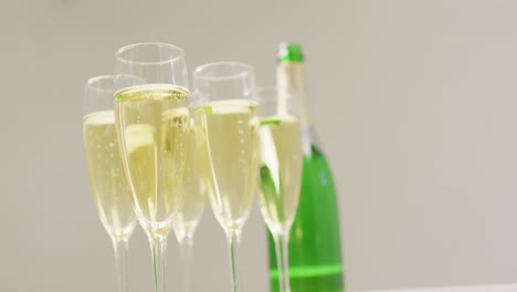 video of champagne in glasses and bottle on beige background