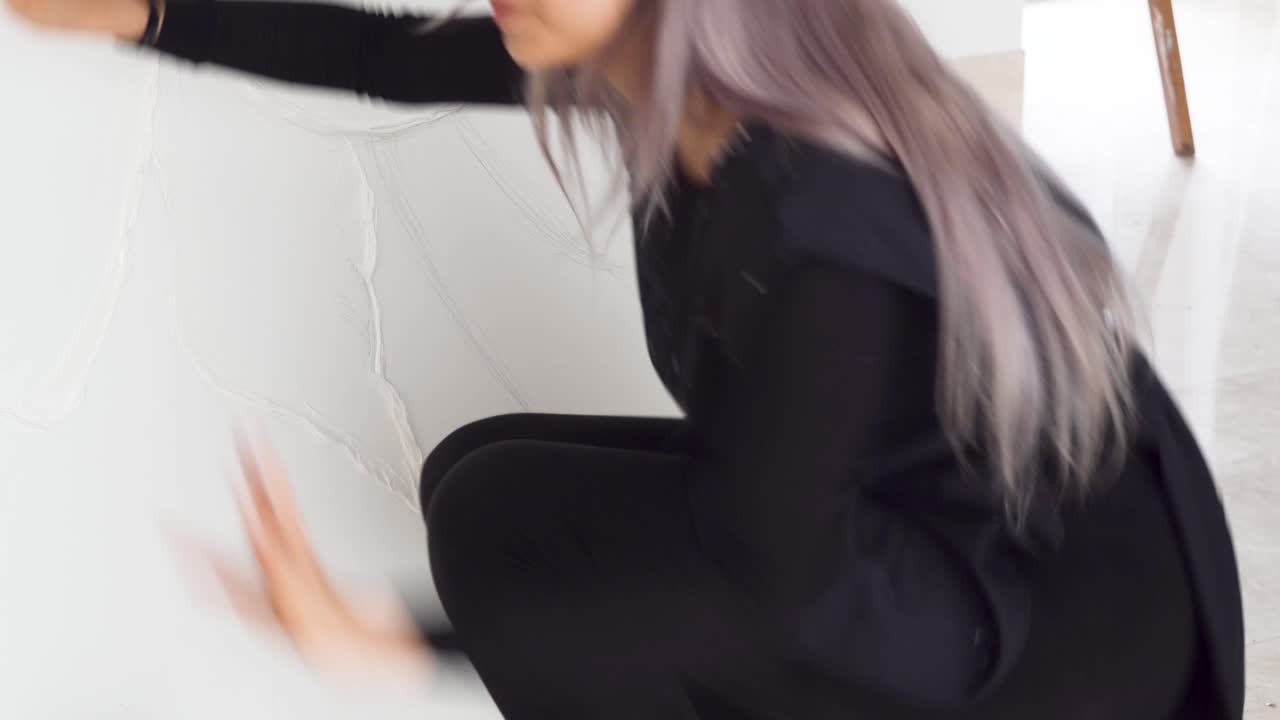 талантливая художница работает над белым холстом в студии