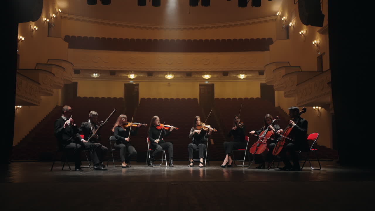 orquesta en la escena de la ópera cuatro violines dos violonchelos fagot y flauta músicos tocando