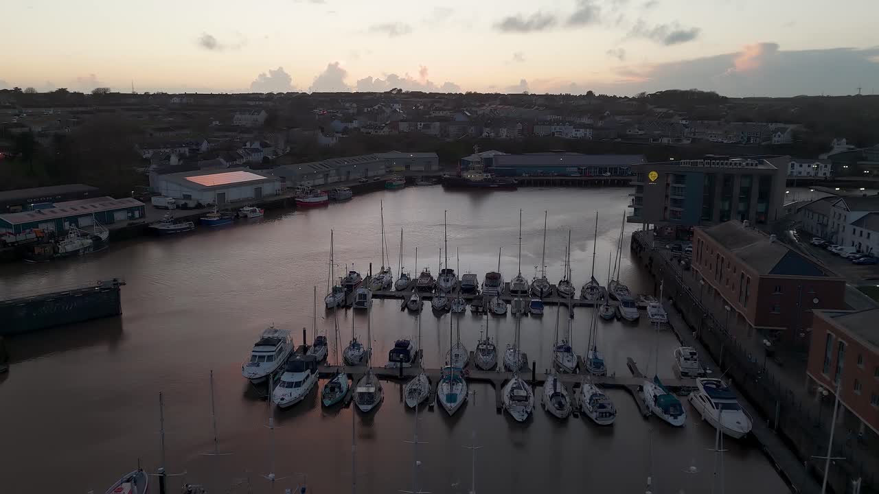 Milford waterfront, showing boats docked in the harbor at sunset, aerial view