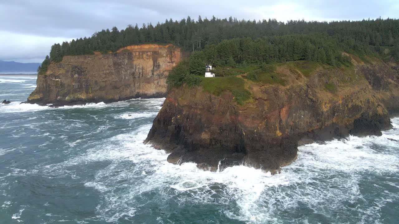 acantilados que se encuentran con el océano y olas que se estrellan en el faro de cabo meares en la costa de oregón