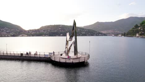 cinematic aerial orbit of the life electric sculpture at lake como, italy